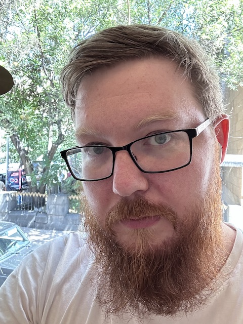 photo of Tim, white ginger-bearded man in glasses